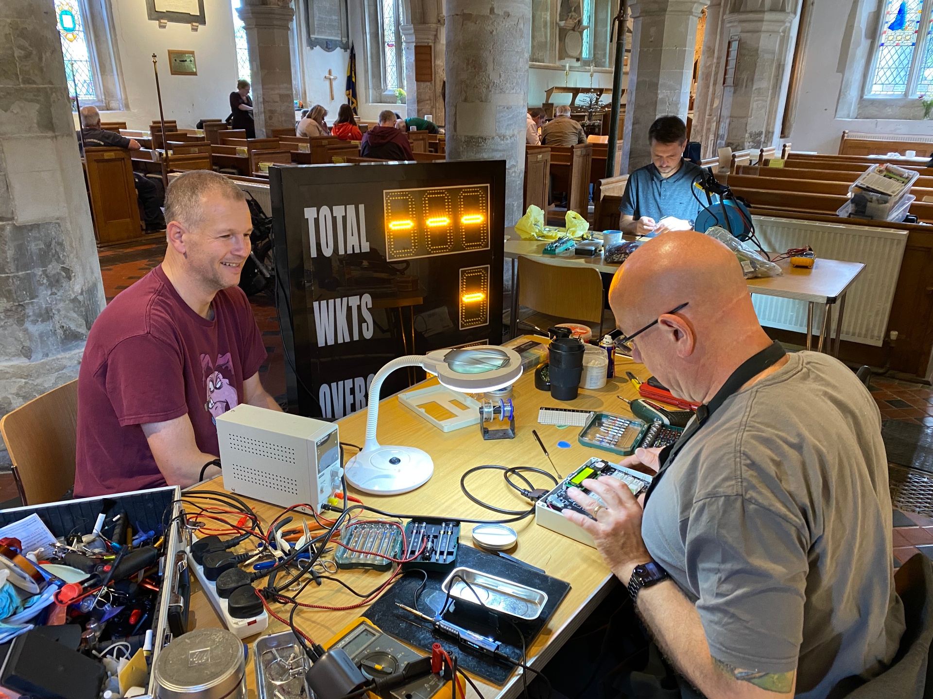 Volunteers repairing electronics side by side