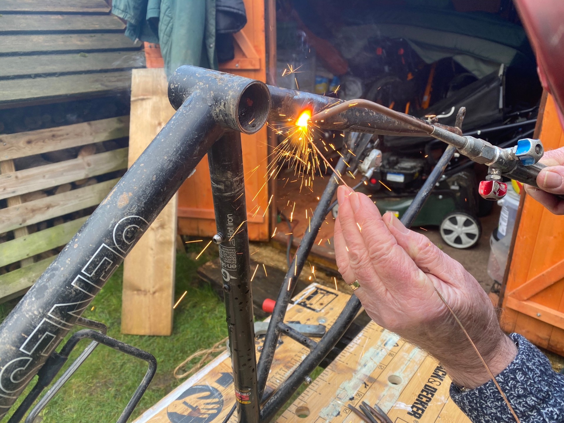 A bike frame being welded — sparks flying
